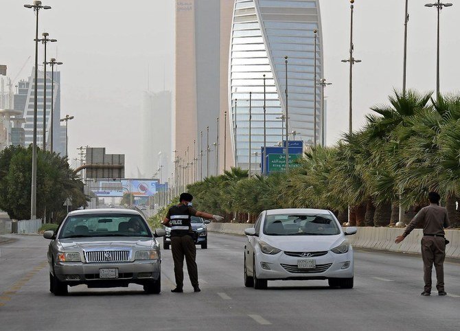 2020年3月26日撮影。サウジアラビア全土で11時間の外出禁止令が始まった後、首都リヤドのキング・ファハド・コーズウェイの検問所で検問を行っている同国の警察官。（AFP）