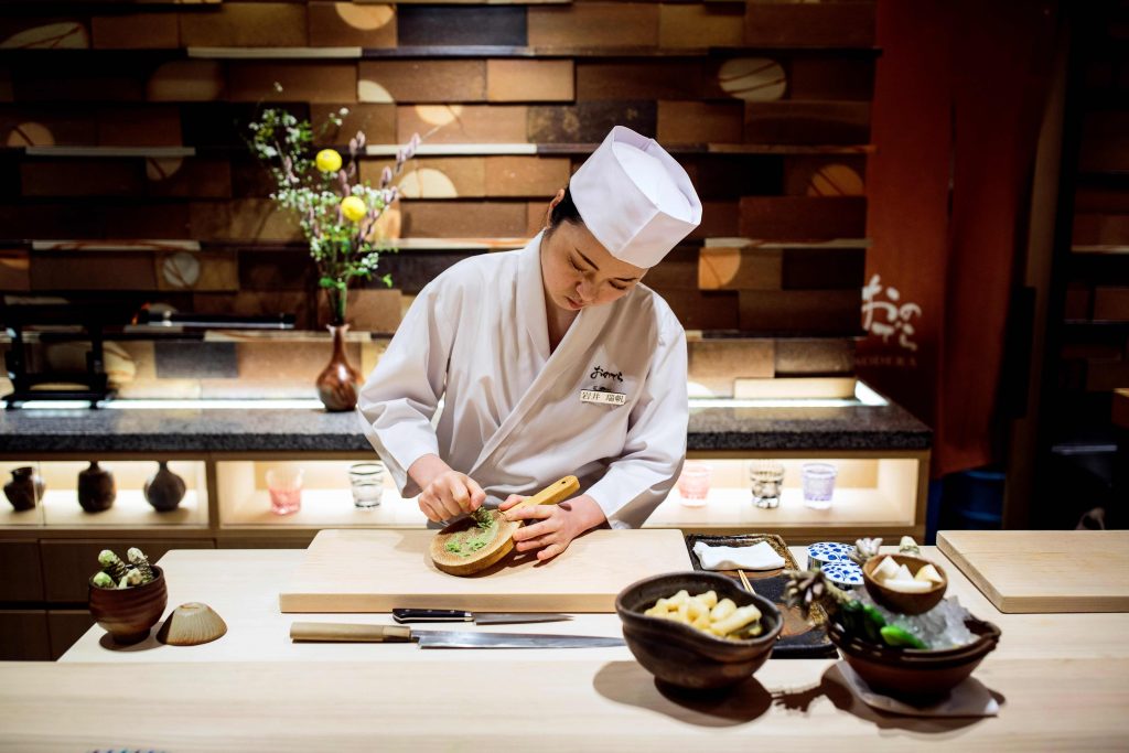 2020年1月16日撮影のこの写真で、東京の「鮨 銀座おのでら」でワサビをおろす同店の見習い、イワイミズホさん。女性は寿司職人になれないという考えを打ち砕こうと挑む日本の女性が増えており、日本でも最も尊敬を集める名店の数々で板前の修行を積み、働いている。（AFP）