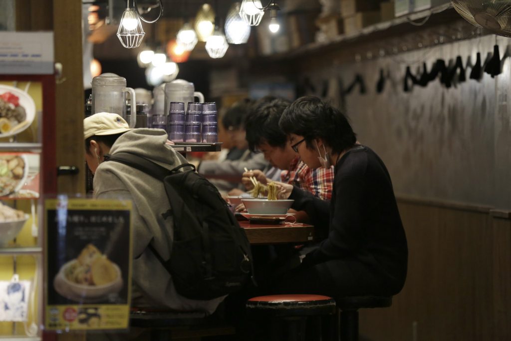 新型コロナウイルスの緊急事態にあり、日本の人々は外出自粛を要請されている。しかし多くの人が従っていない。感染リスクがあっても通勤しなければならない人々もいれば、外食したり公園でピクニックしたり、社会的距離をあまり気にかけることなく食料品店に殺到したりする人々もいる。（AP通信 写真）