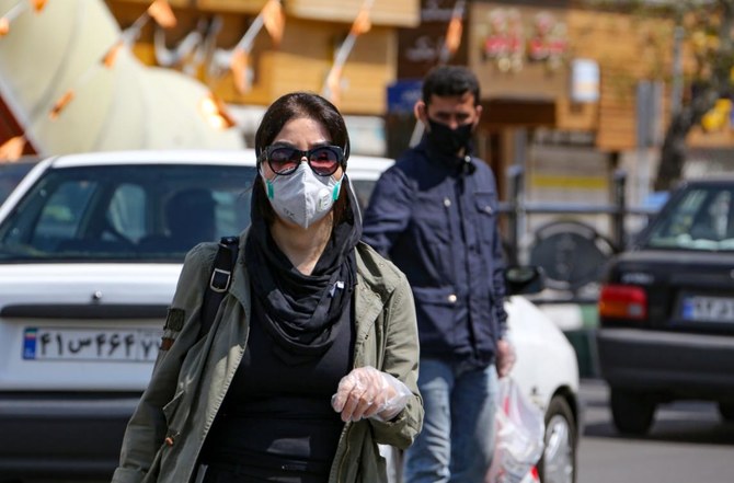 2020年4月5日、新型コロナウイルス予防のマスクを着けたイラン女性が首都テヘランの通りを歩いていく。（AFP 通信）