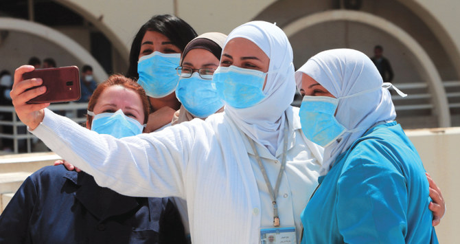 医療従事者が、コロナウイルスのパンデミックの中、ベイルートの大病院で病院職員と患者を支援して開催された音楽会でセルフィーを撮っている。（AFP）