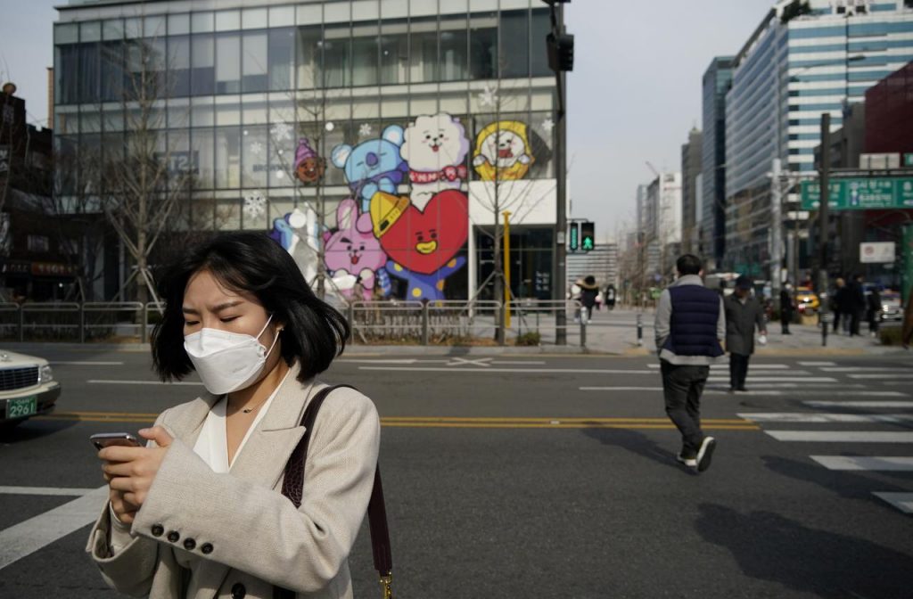 韓国ソウルのショッピング街でコロナウイルスの感染防止のためマスクを着用した女性が、携帯電話を使用している。 （ロイター）