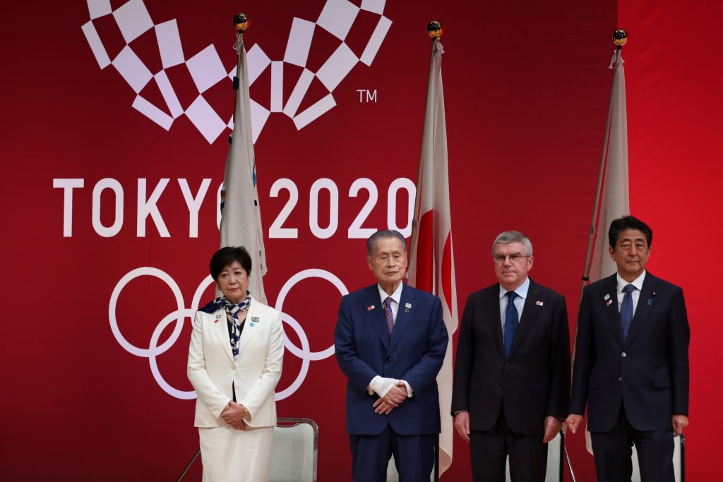 東京2020オリンピック開幕1年前の式典に出席する小池百合子東京都知事、東京2020組織委員会森喜朗会長、国際オリンピック委員会トーマス・バッハ会長、日本国安倍晋三総理大臣。（AFP）