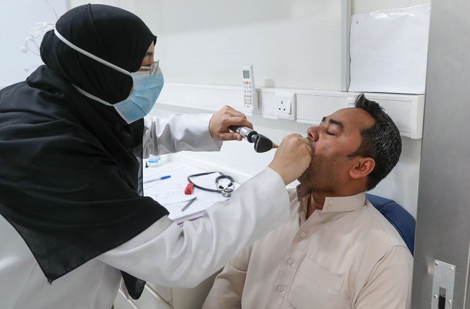 聖地メッカのアジャド・アルマサフィ地区住民向け移動クリニックで患者を診察するサウジアラビア人看護師。2020年4月7日。（ファイル/ AFP）
