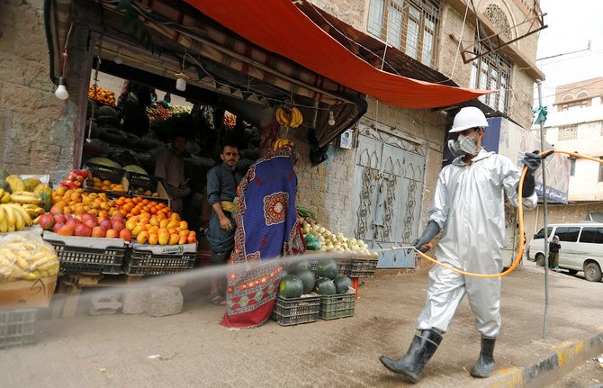 2020年4月28日、イエメンのサヌアでコロナウイルス(COVID-19)が蔓延する懸念がある中、防護服を着た医療従事者が市場を消毒。(ロイター)