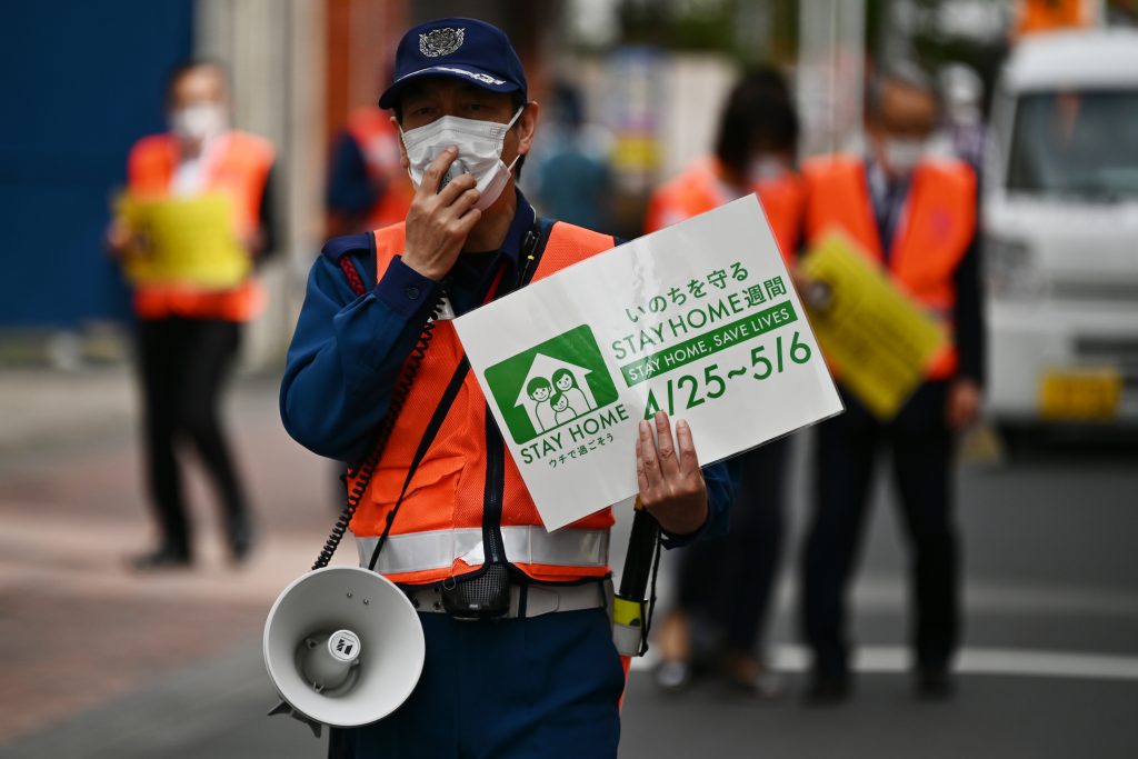 COVID-19コロナウイルスが大流行する中、東京の街頭をパトロールして人々に家にいるように求める地方公務員たち。2020年5月4日。（AFP）
