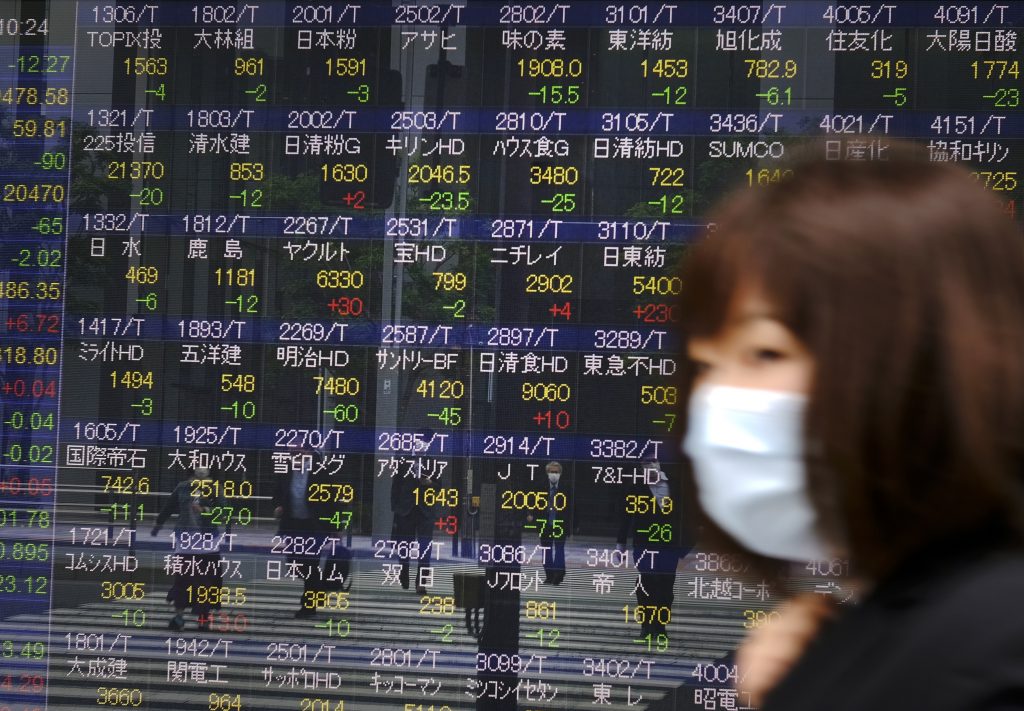 2020年5月22日、東京都内にある東京証券取引所の電子式気配板の前を歩く女性。（AFP）
