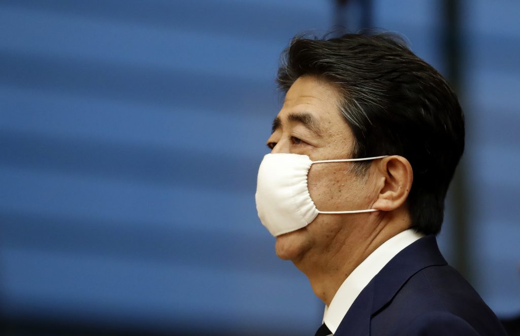 2020年5月25日、東京での記者会見会場にマスクを着用して入場する日本の安倍晋三首相（左）。（AFP）