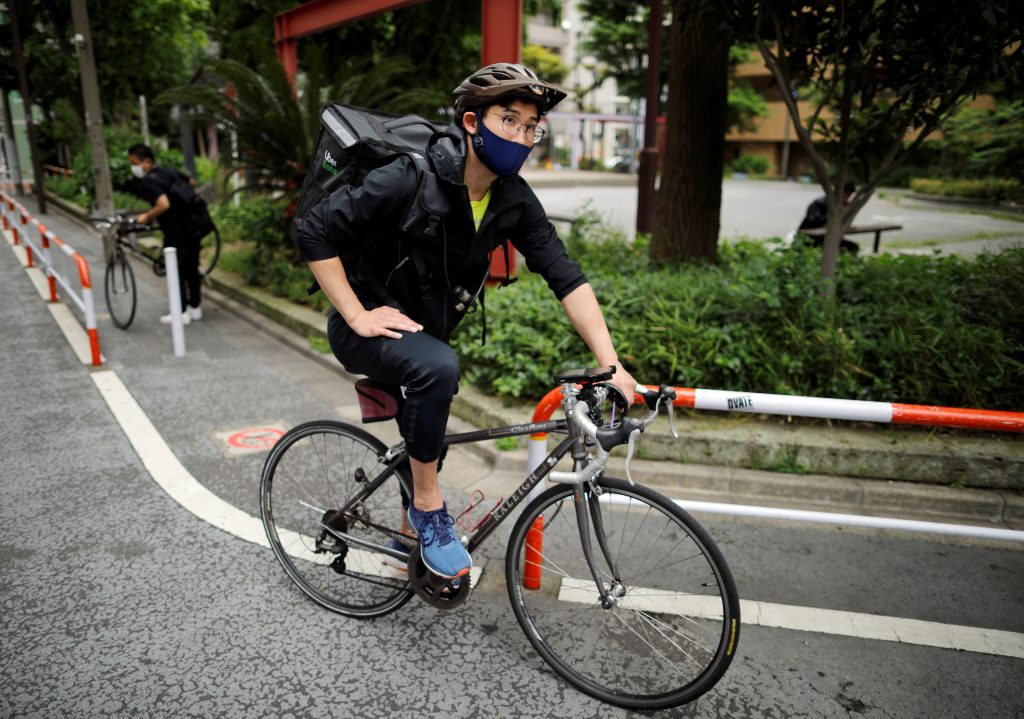 2020年5月12日、 コロナウイルス感染症の拡大で全国的な緊急事態が続くなか、東京でUber Eatsの配達員アルバイトとして自転車をこぐオリンピック日本人メダリストの三宅諒さん。(File photo/Reuters)