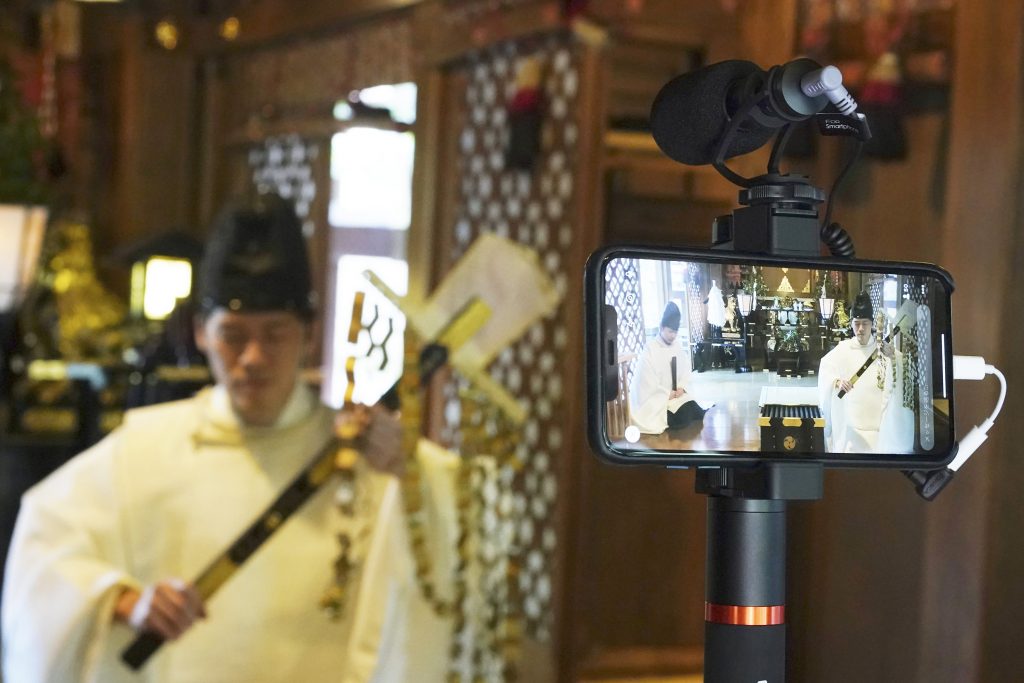 2020年5月8日、東京の下町の小野照崎神社により10日間にわたり行われた「オンライン神社」参拝プログラムの試みで、祈祷のライブストリーミングを行う宮司のオノ・リョウキさん。参拝者が自宅から祈祷に参加できるようにした。(AP)