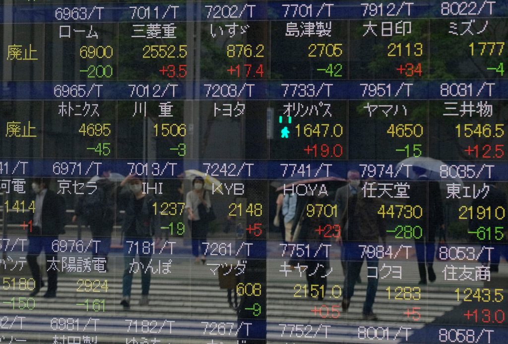 2020年5月18日、東京都内の東京証券取引所の株価を表示する窓に歩行者が映っている。(AFP)