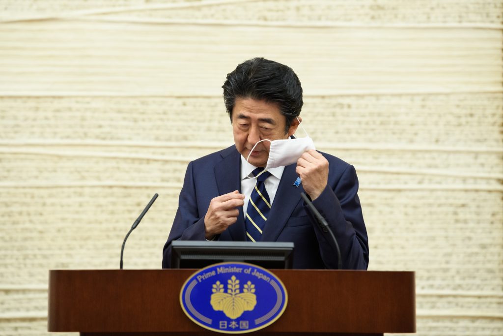 東京の首相官邸での記者会見中、話す前にマスクを外す日本の安倍晋三首相。2020年5月14日。（AFP）