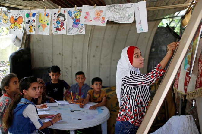 コロナウイルスの影響で休校中、近所の子どもたちにアラビア語の授業を行うパレスチナの学生Fajr Hmaid（13歳）。（ロイター通信）
