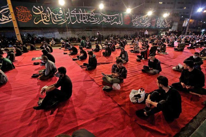 2020年5月13日、イスラム教のラマダンの断食期間中でも最も神聖なる日の夜、テヘランにあるモスクの外で、Covid-19 コロナウィルス予防のためのマスクをしたイラン国民がライラ・アルカドルの礼拝に参列。（AFP）