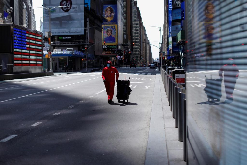 COVID-19が大流行する中、ほとんど人気のないマンハッタンのタイムズスクエアを通り抜ける街路清掃人。2020年4月7日、米国ニューヨーク市。（ロイター）