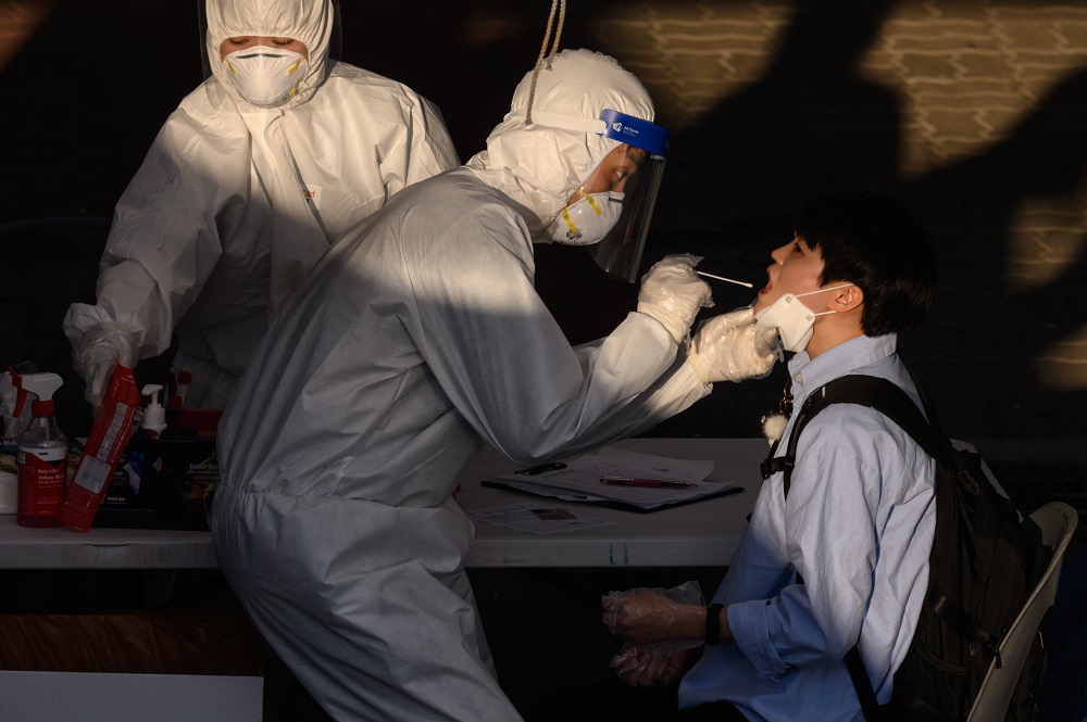 2020年5月27日、ソウル市の西にあるプチョン市のCOVID-19新型コロナウイルスの特設検査センターで、医療従事者が綿棒で鼻腔から検体を採取している。（AFP通信）