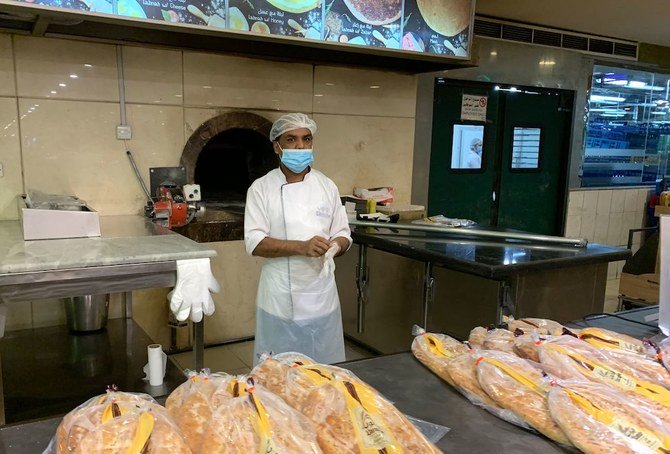 2020年5月14日、新型コロナウイルスによるロックダウンが当局により部分的に緩和されたことをうけて、サウジアラビアの首都リヤドにある閑散としたハヤット・モールでパン屋の従業員が客が来るのを待っている。(AFP)