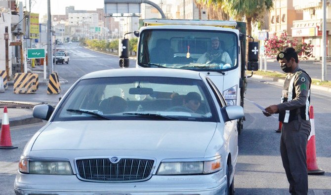 日曜、タブク県ウムルジの道路沿いで運転手をチェックする、外出禁止令取り締まり中の警察。（SPA）