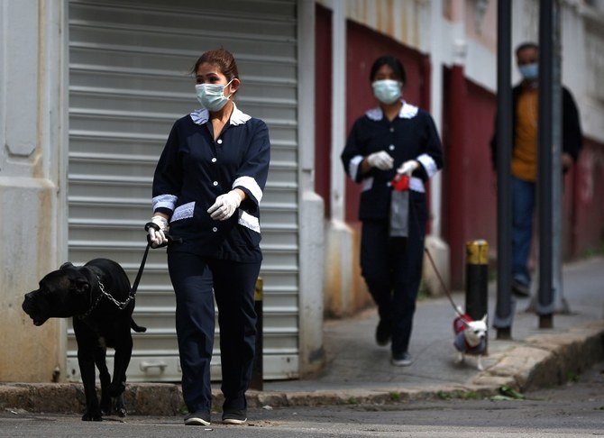 レバノンの首都ベイルートで、マスクをした外国人家政婦らが雇用主の犬を散歩させている。(ファイル/AFP)