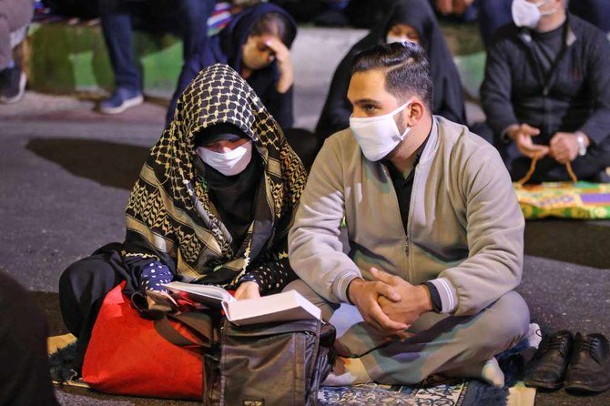 テヘランのモスクの外でCOVID-19コロナウイルス対策のマスクを着用してライラトルカドルの祈りに参加するイラン人たち。2020年5月13日。（AFP/アッタ・ケナーレ）