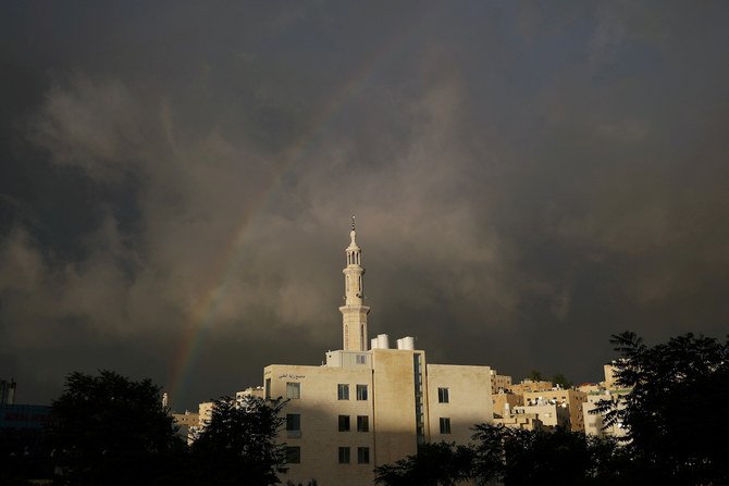 コロナウイルス感染症（COVID-19）の拡大の中で政府が課した完全なロックダウン後のイド・アル＝フィトルの初日に、閉鎖されたモスクの上にかかった虹。ヨルダンのアンマンにて、2020年5月24日撮影。（ロイター）