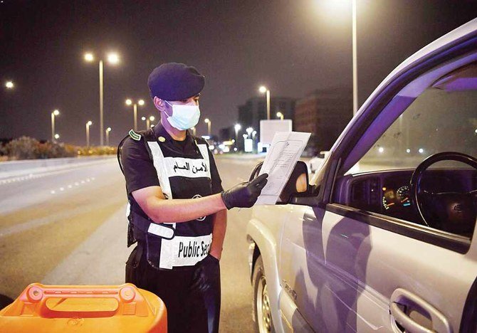 ジッダで運転手たちに検問を行う保安当局者。コロナウイルスの拡散を制限するため外出禁止を執行している。（SPA）