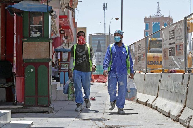 2020年5月17日、マスクを着用してドーハの街を歩く労働者たち。カタールは世界最悪水準のコロナウイルス感染率への対策を講じ、公共の場でマスクを着用しなかった場合の世界で最も厳しい罰則の適用を開始した。(AFP)
