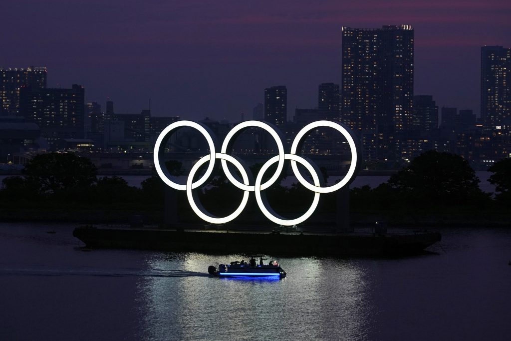 2020年6月3日水曜日、東京のお台場地区で日没時に水に浮かぶ五輪。東京五輪は3月に延期され、2021年7月23日に開催される予定。残り14カ月だが、パンデミックで世界中で旅行が減少する中、IOCも地元主催者も、どのように大会を開催できるかを説明していない。(AP Photo)