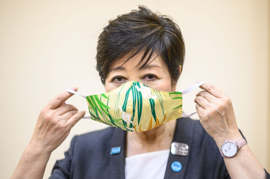 東京都庁でAFPのインタビューの後、ホノルル市長から贈られたハワイアン柄のマスクを着けて写真撮影のためポーズを取る小池百合子東京都知事。2020年6月12日撮影。来年のオリンピックはコロナウィルスのパンデミックにもかかわらず安全なものになると小池百合子東京都知事は言い、史上初めて延期された大会を確実に開催できるようにするため「120%の努力」を約束した。（AFP）