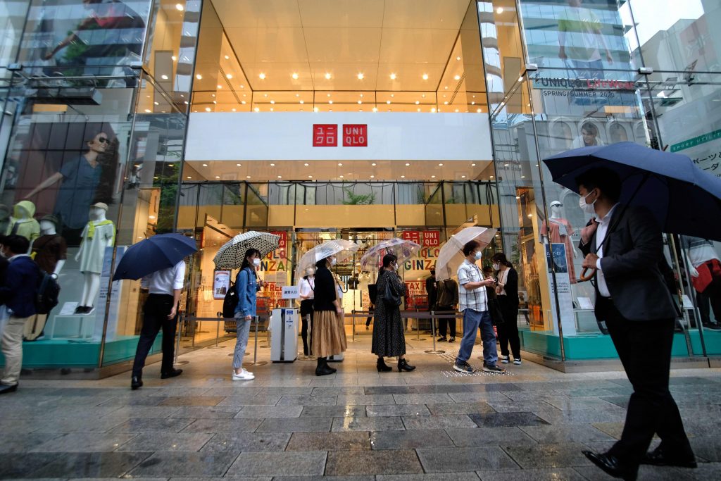 2020年6月19日、東京銀座のショッピング街で、日本のファーストリテーリング社製マスクを販売するユニクロ店舗の外で買物客が列を作って待っている。（AFP通信）