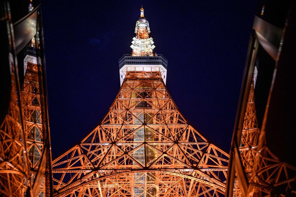 東京で行われたドライブインシアター・イベント中にライトアップされた東京タワー。このイベントはCOVID-19コロナウィルス・パンデミックにより社会的制約が課せられる中の2020年6月20日に開催された。（AFP）