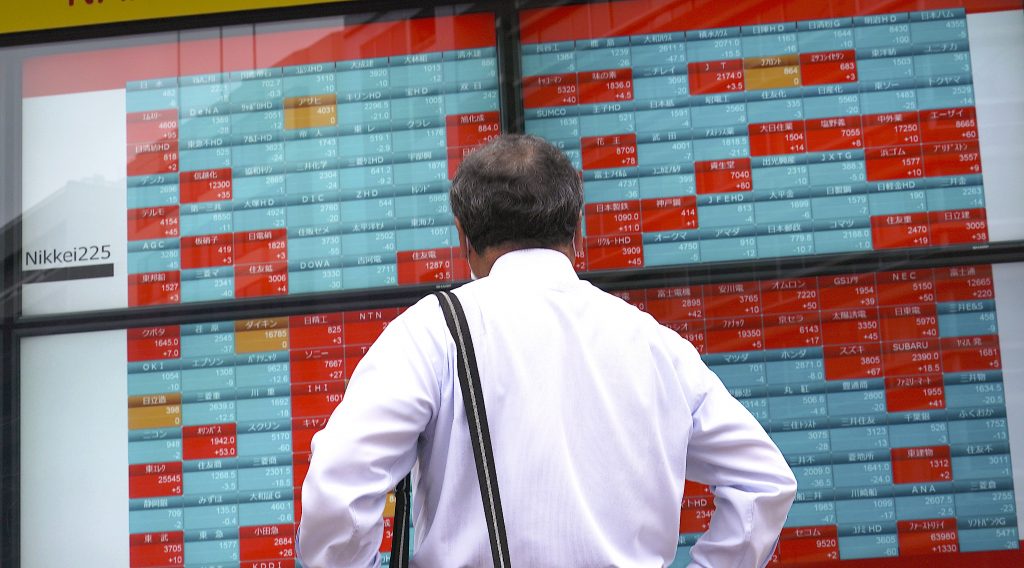 2020年6月24日、東京の証券会社で日経225指数の電光掲示板を見る男性(ファイル写真/AP)