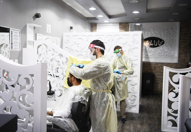 COVID-19の感染拡大の防止を目的とした3ヶ月のロックダウン期間後、営業再開の安全要件の一部として防護服を着用している理髪師。（SPA）