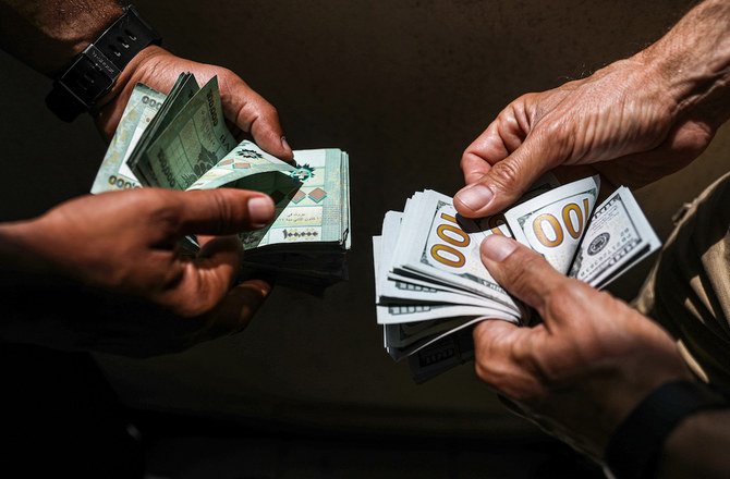 2020年6月18日、レバノンの首都ベイルートの闇市場でレバノンのポンド紙幣と米ドル紙幣を両替する人々。（AFP）