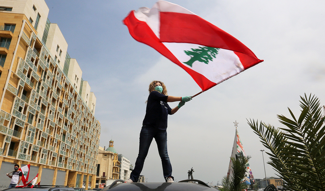 ベイルートでレバノンの国旗を掲げる反政府デモ隊。(ロイター/提供)