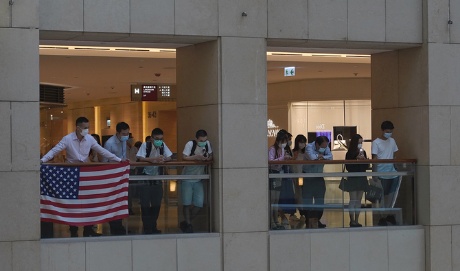 2020年6月1日、香港のショッピングモールで、中国の国家安全保障法制に反対する抗議行動中に、抗議者が米国旗を掲げている。(AP)