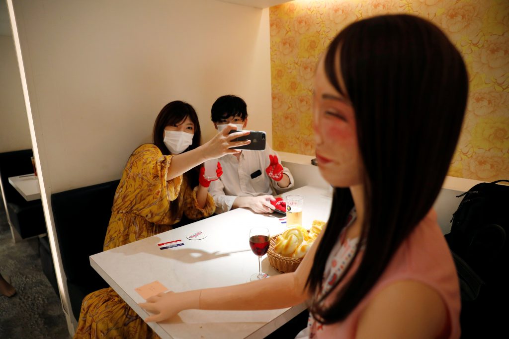 チアリーダー衣装姿のマネキンが置かれたテーブルに座る客たち。このマネキンは、新型コロナウイルス感染症（COVID-19）の感染拡大のさなか、2020年6月3日に、日本の東京にあるチアリーダーをテーマにした飲食店「Cheers One」で社会的距離を取るために置かれたもの。写真は2020年6月3日に撮影。（ロイター）