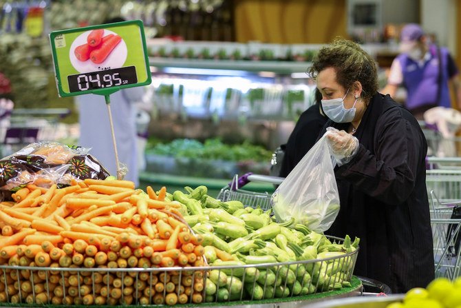 2020年6月14日、新型コロナウイルス感染症（COVID-19）の発生を受けて、フェイスマスクをつけてスーパーで野菜を購入する女性。サウジアラビアのリヤドにて。（ロイター）