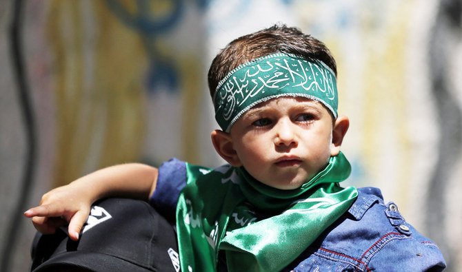 ガザ地区で、イスラエルの併合計画に反対する抗議行動にヘッドバンドをつけたパレスチナ人の少年が参加している。(ロイター通信)