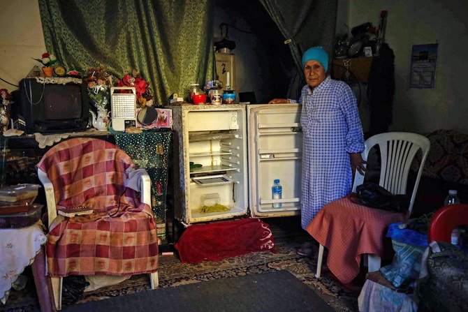 ベイルート北部の港街トリポリのアパートで、空っぽの冷蔵庫の横に立つレバノン人女性。2020年6月17日。（AFP）