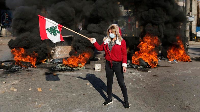 デモ活動中に国旗を振る反政府デモ参加者。レバノン、ベイルート。2020年1月14日。（写真・AP通信）