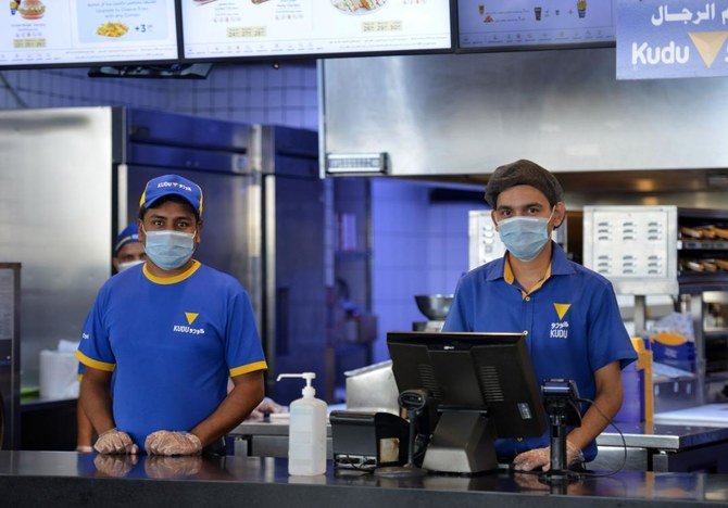 サウジアラビアの首都、リヤドのショッピングモールにあるレストランの従業員が、マスクを着用している様子。2020年6月4日。（AFP）