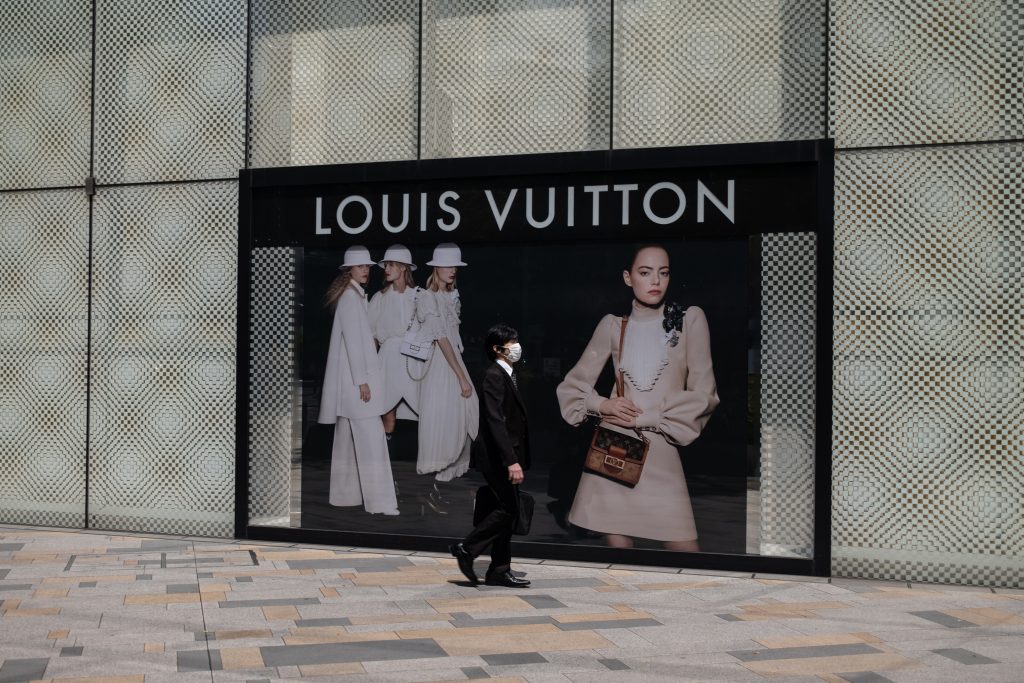 2020年5月7日、東京のルイ・ヴィトンの店の外を歩く、マスクを着けた男性（AFP）。