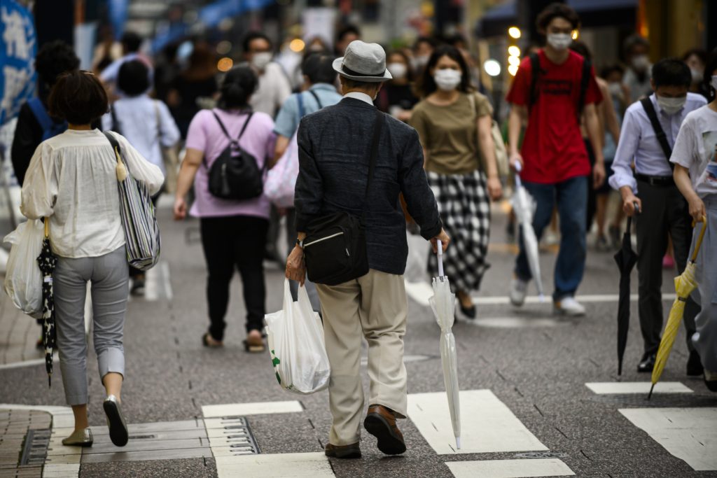 2020年7月1日、東京で買い物をレジ袋に入れて運ぶ男性。（AFP）