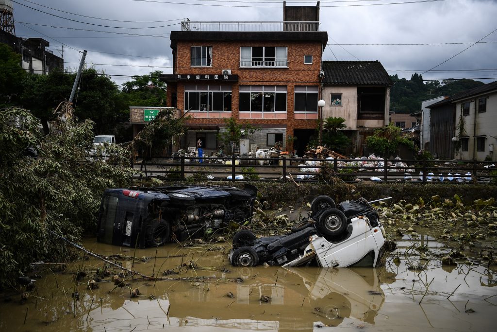 2020年7月9日、人吉で発生した大雨と洪水により川で損傷して横転した車両。(AFP)