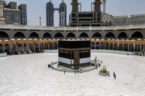 2020年7月24日の年恒例大巡礼ハッジに先立ち、サウジアラビアの聖なる都市メッカにあるグランドモスクの施設で作業員たちが新型コロナウイルス感染拡大のためにマスクを着用し、施設中央にあるイスラム教の最高に聖なる神殿であるカーバ周辺で作業している。