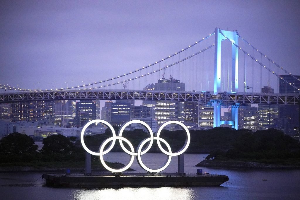 レインボーブリッジを背景にライトアップされる巨大な五輪モニュメント。2020年7月 16日、東京 (資料写真 / EPA)