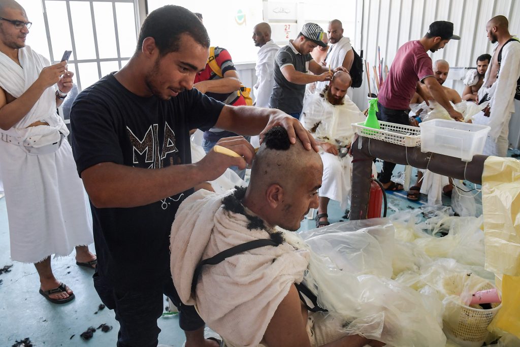 理髪師から頭を剃られるイスラム教徒の巡礼者。（AFP）