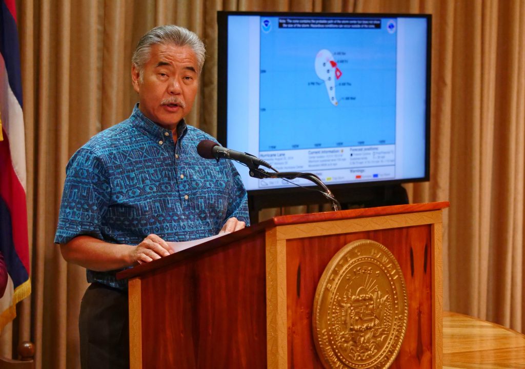 記者会見で発言するハワイ州知事のデービッド・イゲ氏(中央):2018年8月22日ハワイ州ホノルル(AFP)