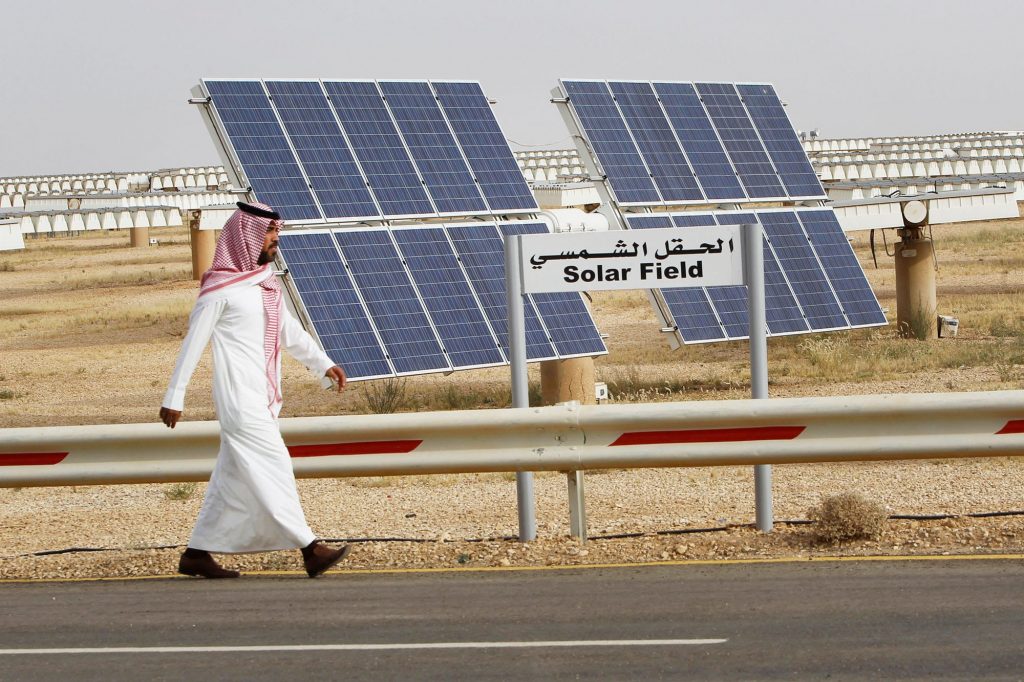 リヤドのキング・アブドゥルアジズ科学技術都市のアル・オイェイナ研究ステーションで一面のソーラーパネルの前を歩くサウジアラビア人男性。（ロイター）